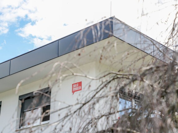 Tiroler Immobilien Schild auf Gebäude | © Roland Defrancesco